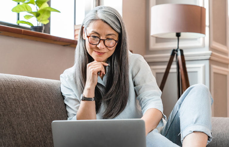 Woman on couch using a laptop computer.